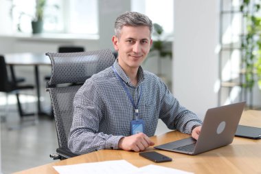 Ofiste dizüstü bilgisayarla çalışan mühendisin portresi