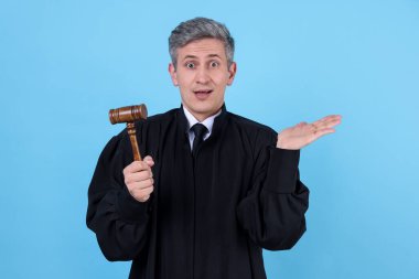 Açık mavi arka planda tokmağı olan duygusal yargıç.