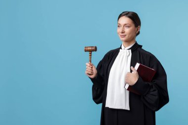 Açık mavi arkaplan üzerine kitap ve çekiçle yargıla, metin için boşluk