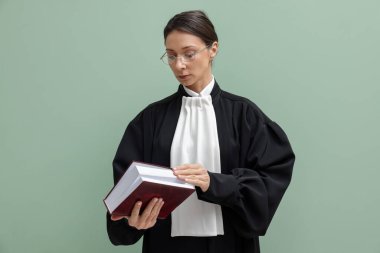 Açık yeşil arkaplan üzerine kitabı olan yargıç