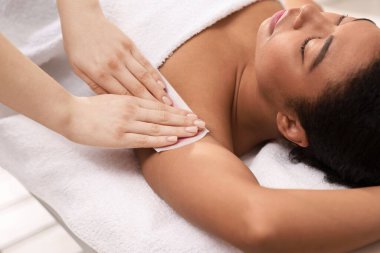 Güzellik salonunda balmumu epilasyon ameliyatı olan bir kadın.