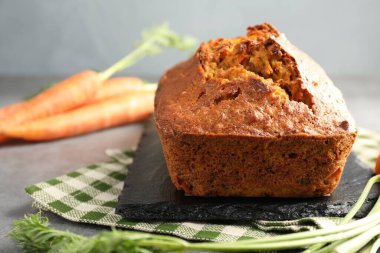 Gri desenli masada havuçlu kek ve sebzeler, yakın plan.