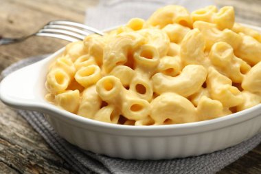 Peynir soslu lezzetli makarna ve ahşap masa üzerinde çatal, yakın çekim.