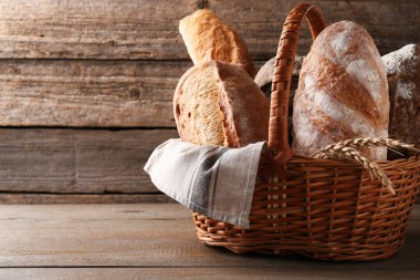 Tahta sepetin üzerinde farklı somun taze ekmek ve çiviler, metin için yer.