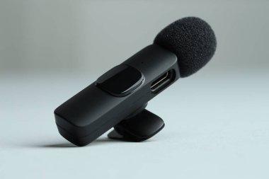 Gri arka planda Lavalier mikrofonu, yakın plan. Ses ekipmanları