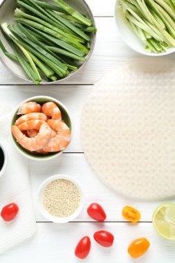 Pirinç kağıt çarşaflar ve beyaz ahşap masa üzerindeki farklı malzemeler.