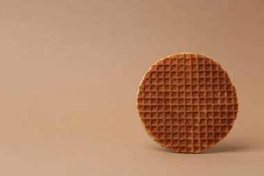 Kahverengi arka planda lezzetli yuvarlak bir waffle. Metin için boşluk
