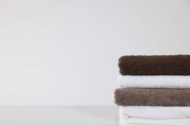 Beyaz masaya bir yığın temiz havlu, yakın plan. Metin için boşluk