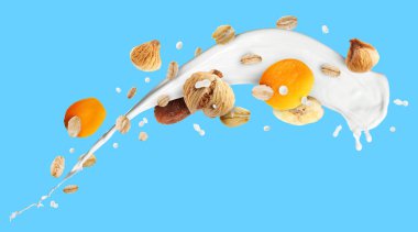 Süt sıçraması, yulaf ezmesi ve açık mavi arka planda kurutulmuş meyve. Pankart tasarımı