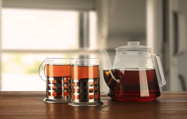 Taze demlenmiş çaydanlıklar tutacaklarda ve çaydanlıklar trende masada.