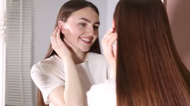 Güzel bir kadın aynada kendine bakıyor.