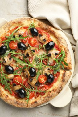 Mantarlı lezzetli pizza, zeytin ve roka açık gri masa, üst manzara.