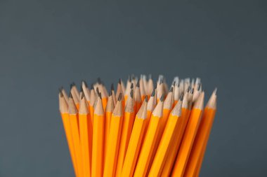 Gri arkaplanda birçok grafit kalem, yakın plan