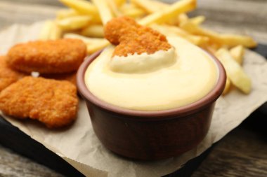 Lezzetli peynir sosu, tavuk nugget ve patates kızartması masada, yakın plan.