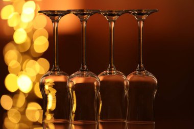 Bulanık ışıklara karşı cam ayna yüzeyinde birçok temiz bardak var. Bokeh etkisi