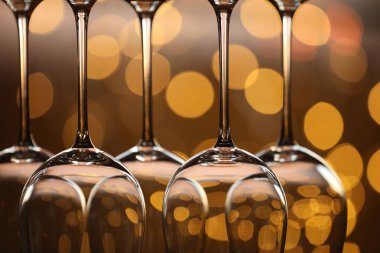 Bulanık ışıklara karşı birçok temiz bardak, yakın plan. Bokeh etkisi