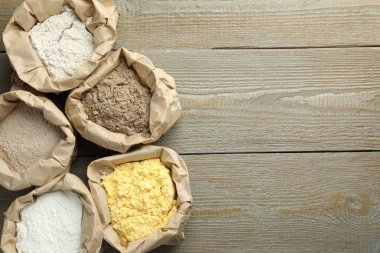 Tahta masadaki kağıt torbalarda farklı türde un var. Metin için boşluk