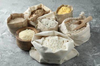 Gri desenli masa üzerinde farklı tipte un, yakın plan.