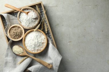 Açık gri masadaki farklı un türleri, üst görünüm. Metin için boşluk