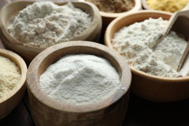 Tahta masadaki kaselerdeki farklı un türleri, yakın plan.