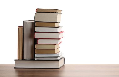 Beyaz arka plana karşı ahşap masada birçok eski kitap