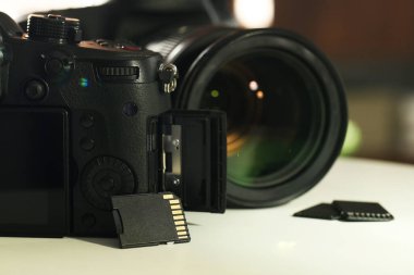 SD hafıza kartları ve fotoğraf makineleri beyaz masada, yakın plan