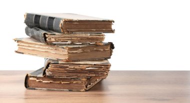 Tahta masadaki eski kitaplar beyaz arka plana karşıdır