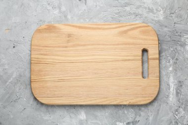 Açık gri desenli bir masada ahşap servis tahtası, üst manzara. Metin için boşluk