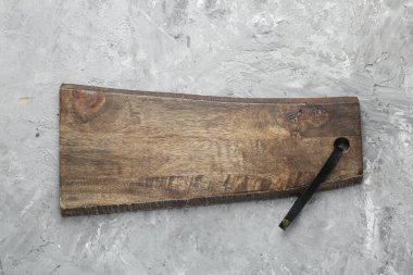 Açık gri desenli bir masada ahşap servis tahtası, üst manzara. Metin için boşluk