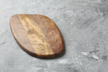 Açık gri desenli bir masada ahşap servis tahtası, yakın plan. Metin için boşluk