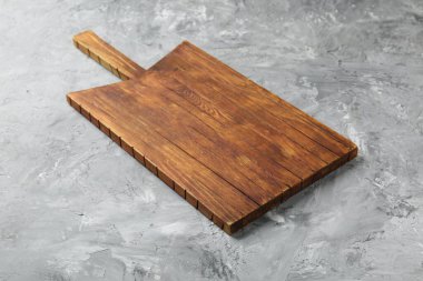 Açık gri desenli bir masada ahşap servis tahtası, yakın plan. Metin için boşluk