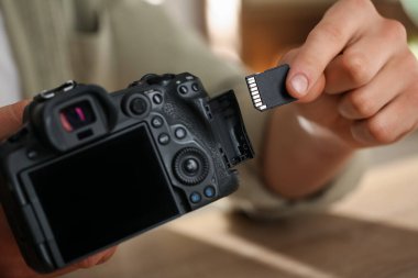 SD bellek kartını fotoğraf makinesine yerleştiren adam, kapat