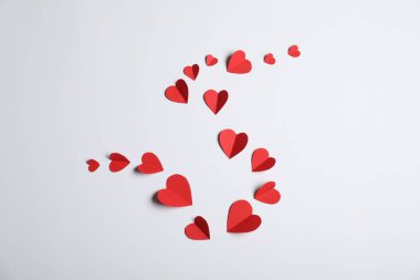 Açık gri arkaplanda bir sürü kağıt kalp var.