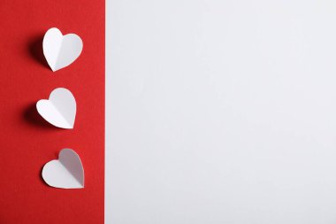 Beyaz zemin üzerinde kağıt kalpler olan kırmızı çarşaf, düz yatıyordu. Metin için boşluk