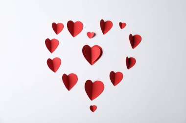 Açık gri arkaplanda bir sürü kağıt kalp var.