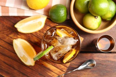 Küba libre kokteyli ve ahşap masa üzerindeki malzemeler tazeleniyor.