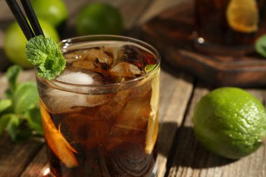 Küba libre kokteylini ahşap masada nane şekeri ile tazeliyorum.