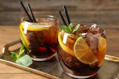 Küba libre kokteylini ahşap masada nane şekeri ile tazeliyorum.