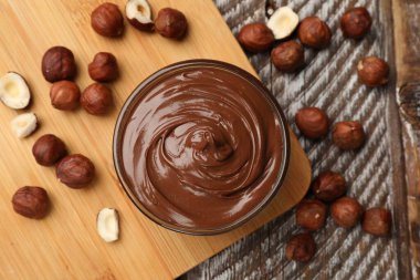 Fındıklı çikolata kâse ve fındıklar ahşap masaya serilmiş.