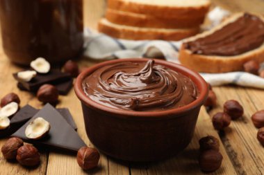 Lezzetli fındık ezmesi, çikolata parçaları ve fındıklar ahşap masada, yakın plan.