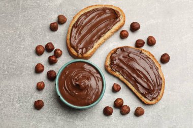 Lezzetli çikolata fındıklı tostlar ve gri masada fındıklar, düz yatış.