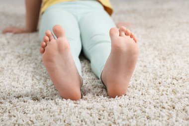 Evdeki yumuşak halıdaki kız, yakın plan.