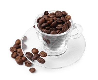 Aromatik kahve çekirdekleri ve çay tabağı beyaza izole edilmiş.