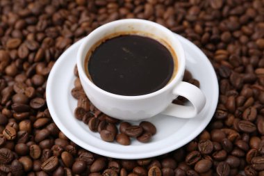 Kahve fincanı, fincan tabağı ve fasulye, yakın plan.