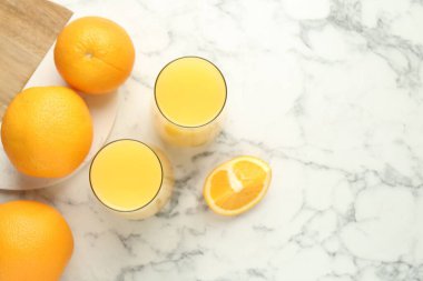 Bardakta portakal suyu ve beyaz mermer masada taze meyveler. Metin için boşluk