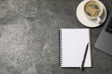Defter, kalem, kahve ve dizüstü bilgisayar gri masada, düz yerde. Metin için boşluk