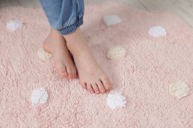 Evdeki yumuşak halıdaki kız, yakın plan.