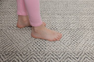 Evdeki gri halıdaki kız, yakın plan.