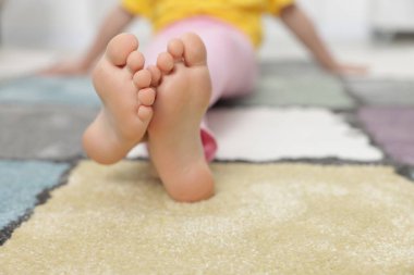 Evdeki yumuşak halıdaki kız, yakın plan.