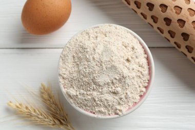 Kâsede un, merdane, yumurta ve çiviler beyaz ahşap masa, düz yatıyordu.